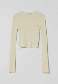 Pull court côtelé de couleur jaune clair, avec manches longues et anneaux en métal sur les côtés. Texture douce en maille.