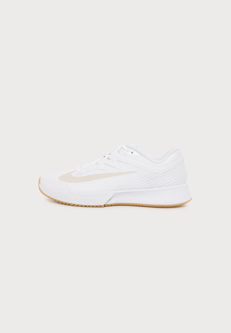 Λευκό αθλητικό παπούτσι με λογότυπο Swoosh ανοιχτού μπεζ και σόλα χρώματος καουτσούκ, εμφανίζεται από το πλάι σε απλό φωτεινό φόντο.