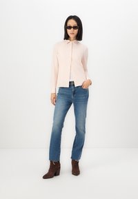 Kerge roosa nööpupühi särk, pikad varrukad, klassikaline krae. Sobib siniste sirgete teksade ja pruunide kontsadega ankle kingadega. Sile tekstuur.