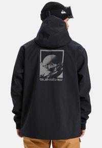 Black hooded jacket with a graphic design featuring mountains and a moon. Material appears smooth; has elastic cuffs and a relaxed fit.