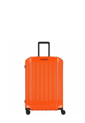 Valise rigide orange avec texture rainurée verticale, poignée téléscopique noire et quatre roues pour la mobilité.