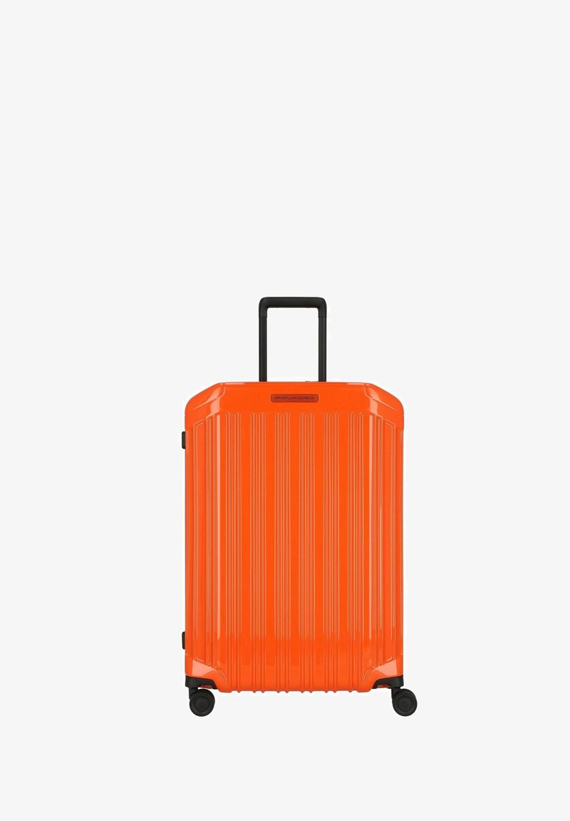 Oranje harde koffer met verticale ribbelstructuur, zwarte telescopische handgreep en vier wielen voor mobiliteit.