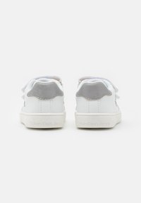 Witte leren sneakers met grijze suède accenten, vetersluiting en een lichte rubberen zool. "Calvin Klein Jeans" is op de hak geperst.