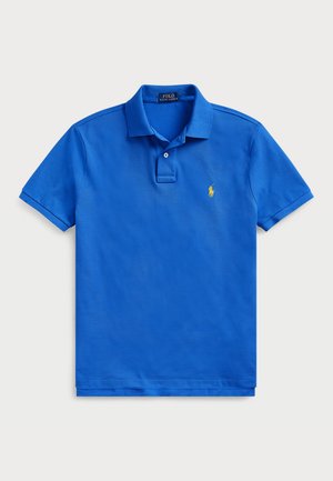 Chemise polo bleue avec col, manches courtes et un petit logo brodé jaune sur la poitrine gauche. Fabriquée en tissu en coton texturé.