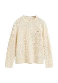 Maglione crema a treccia con scollo rotondo, polsini e orlo a costine. Presenta un sottile logo ricamato sul petto. Tessuto morbido e strutturato.