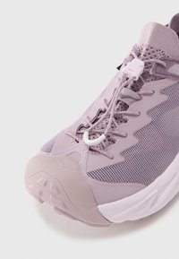 Αθλητικό παπούτσι ανοιχτό μωβ με ανώτερο μέρος από δίχτυ, αντανακλαστικές λεπτομέρειες και χοντρή σόλα. Διαθέτει σύστημα γρήγορου δέσιμου και υφασματικά διακοσμητικά στοιχεία.