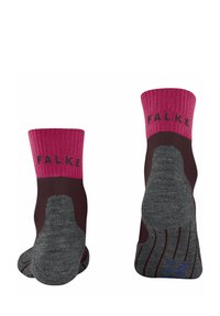 Due coppie di calze esposte, con un bordo rosa e un corpo marrone scuro, dotate di una suola grigia strutturata, etichettate con "FALKE."