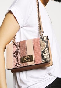 Borsa a tracolla rosa oro e rosa con dettagli in pelle di serpente e glitter, forma rettangolare, hardware dorato e tracolla a catena.