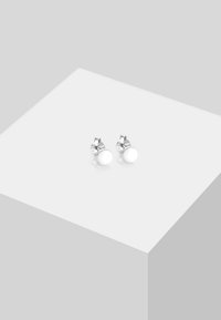 Orecchini a cerchio in argento con retro lucido e piccoli dettagli decorativi, caratterizzati da una superficie brillante e liscia e da un design minimalista.