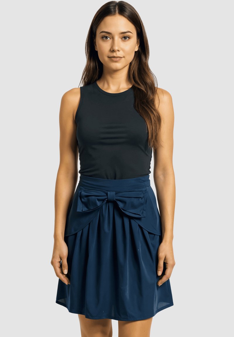 Top negro sin mangas combinado con una falda azul marino que presenta un lazo, una textura fruncida y un acabado de tela suave.