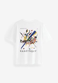 Balta medvilnės marškinėliai su spalvingu abstrakčiu raštu, kuriame naudojami geometriniai formos ir linijos. "KANDINSKY" parašyta ryškiais juodais rašmenimis.