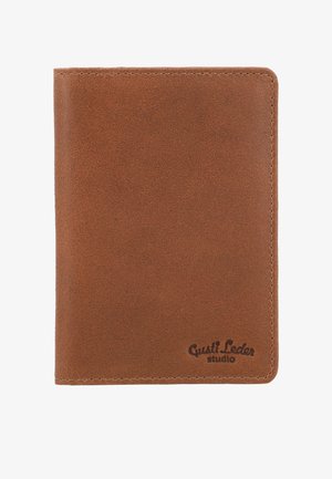 Bruine leren portemonnee met nette stiksels en het logo van "Gusti Leder studio" in reliëf rechtsonder.
