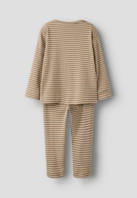 Beige and white striped long-sleeve top with matching leggings, ribbed texture, and a relaxed fit. Simple design with no additional accents.