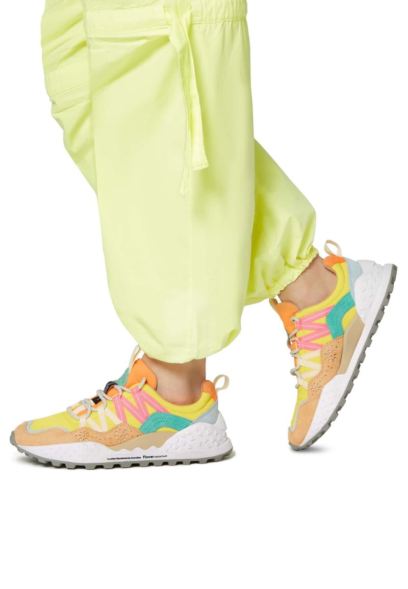 Sneakers colorati con una combinazione di accenti gialli, arancioni, rosa e verdi. Realizzati in tessuto e camoscio, presentano una suola texture e un design giocoso.