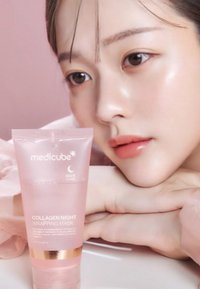 Różowa plastikowa tubka maski na noc Medicube Collagen Night Wrapping Mask ze złotymi akcentami i białym nadrukiem. Gładka powierzchnia, minimalistyczny design.