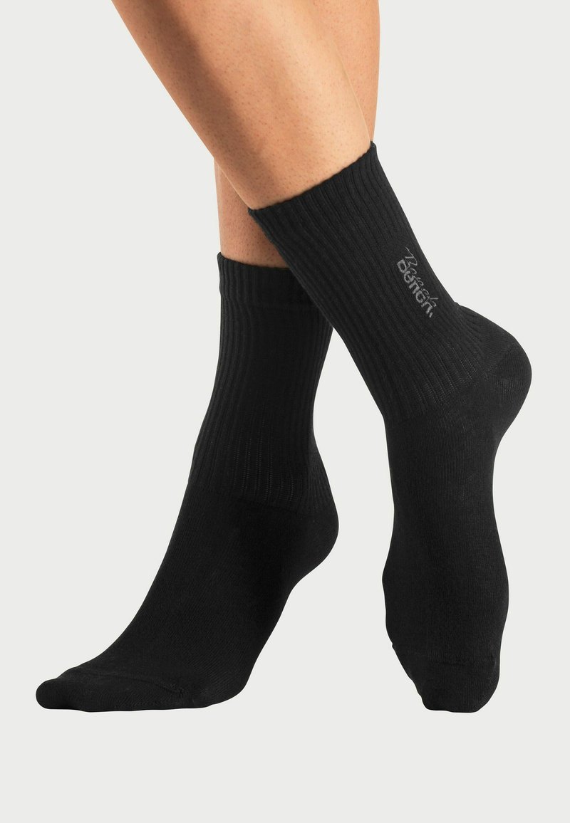 Black ribbed ankle socks with elasticated cuffs, made from a soft material, featuring a subtle logo near the top of the sock.