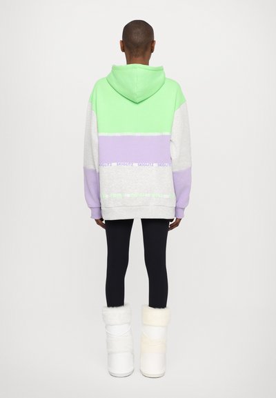Oversized hoodie in mint green, light gray, and lavender with ribbed cuffs and bottom, paired with black leggings and white fur-lined boots.