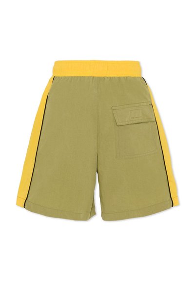 Pantaloncini verde oliva con una fascia elastica gialla in vita, strisce nere laterali e una tasca con toppa sul lato destro. Materiale in cotone, design casual.