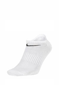 Calcetín blanco hasta el tobillo con textura de canalé, puño acolchado y un logo de swoosh negro de Nike. El material parece elástico y transpirable.