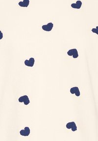 Tessuto bianco con cuori texturizzati blu navy sparsi, creando un motivo giocoso su tutta la superficie. Materiale morbido con una trama uniforme.