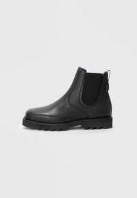 Bottines Chelsea en cuir noir avec des panneaux élastiques sur les côtés, une languette à l'arrière et une semelle en caoutchouc résistante. Fini lisse, design à orteil arrondi.