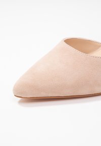 Rosa mockasinfot med spetsig tå och en slät innersula. Yttersulan är ljusbeige, med en enkel, sömlös design.