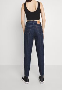 Mörkblå denimjeans med smal passform, som har två bakfickor, en läderetikett på midjebandet och kontrasterande söms detaljer.