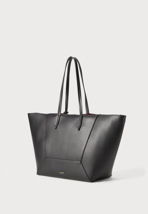 Sac fourre-tout en cuir noir avec deux poignées plates, design angulaire, texture lisse et intérieur rouge contrastant. Présente un accent de logo doré.