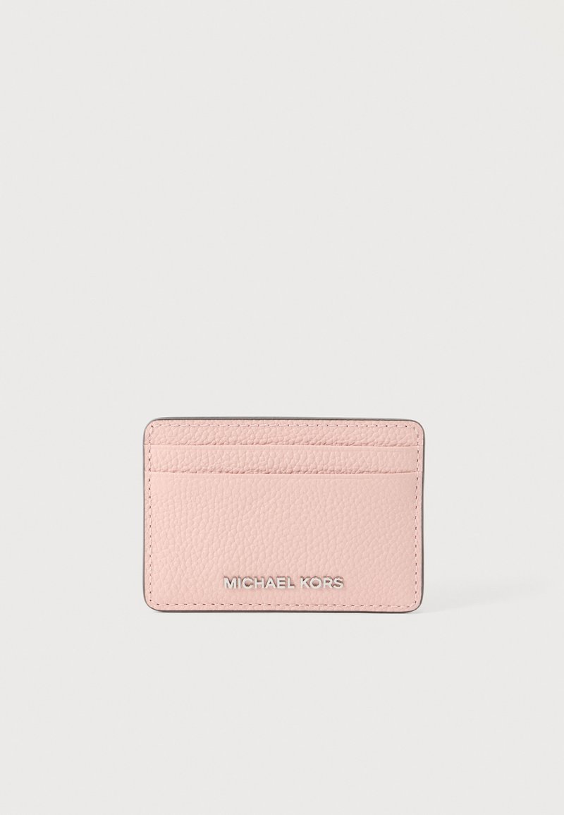 Ροζ υφασμάτινη δερμάτινη θήκη καρτών με τρεις υποδοχές για κάρτες και ασημένιο λογότυπο Michael Kors στο κέντρο μπροστά.