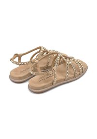 Sandali beige realizzati in materiale simile alla pelle scamosciata, con strass decorativi, suola piatta e una cinghia con fibbia per la regolazione.