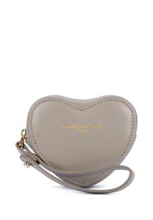 Petite pochette en cuir taupe en forme de cœur avec bracelet et logo doré "Lancaster Paris" sur le devant.