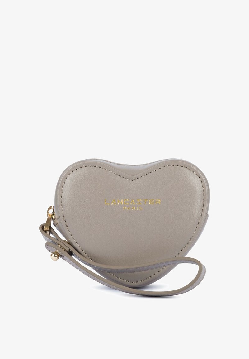 Petite pochette en cuir taupe en forme de cœur avec bracelet et logo doré "Lancaster Paris" sur le devant.