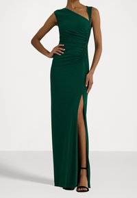 Grön, ärmlös maxiklänning med rynkad byst, asymmetrisk halsringning och hög sidslits. Mjukt tyg med slät textur.