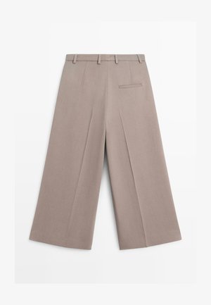 Pantaloni beige a gamba larga con pancia piatta, passanti per cintura e tasca posteriore. Realizzati in tessuto liscio con un aspetto pulito e sartoriale.