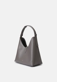 Sac fourre-tout en cuir gris avec une silhouette structurée, une bandoulière ajustable et une ouverture subtile en forme de V. Texture lisse avec détail de logo doré.