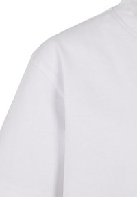 T-shirt en coton blanc avec un col rond, des manches courtes et une texture lisse. Aucune motif ou graphique visible.