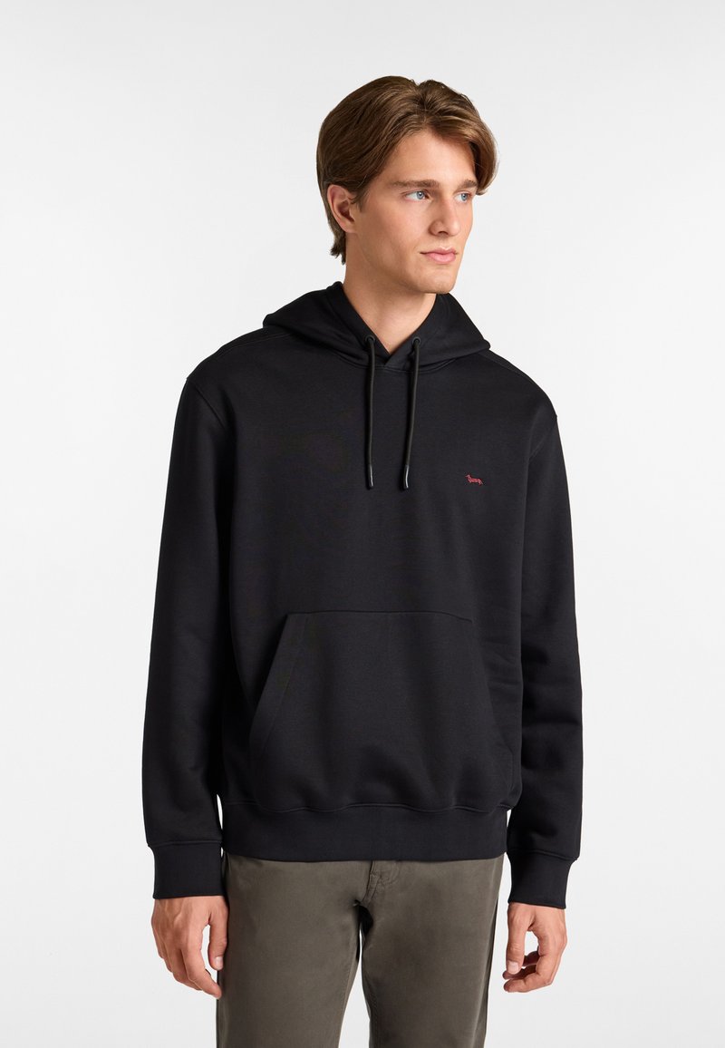 Sudadera negra con bolsillo canguro, que presenta un logo rojo minimalista en el pecho. Fabricada con un tejido suave, tiene un corte relajado y cordones.
