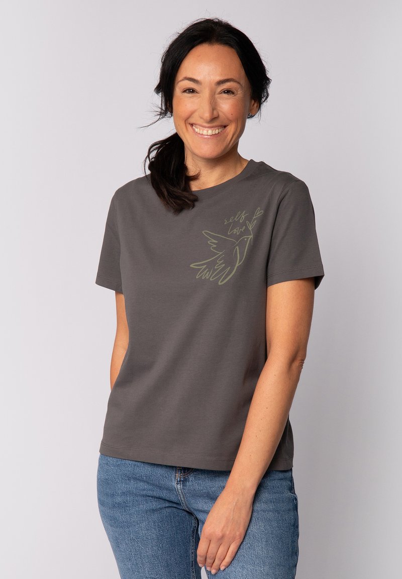 Grau Baumwoll-T-Shirt mit kurzen Ärmeln, featuring ein grünes Grafik eines Vogels und den Text "Selbstliebe" auf der Vorderseite. Lässige Passform.