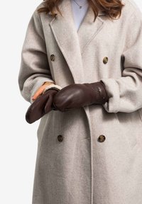 Braune Lederhandschuhe mit glatter Textur, getragen über einem hellgrauen Wollmantel mit großen Knöpfen und einem doppelt geknöpften Design.