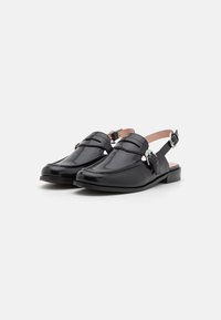 Black patent leather slingback shoes with a rounded toe, flat heel, and two decorative bands across the front. Features a buckle closure.