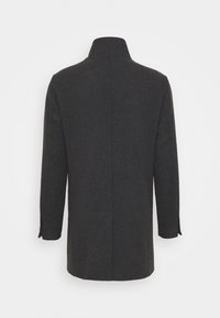 Abrigo de lana oscuro con cuello alto, mangas largas y corte recto. Presenta costuras mínimas y ninguna herrajería visible.