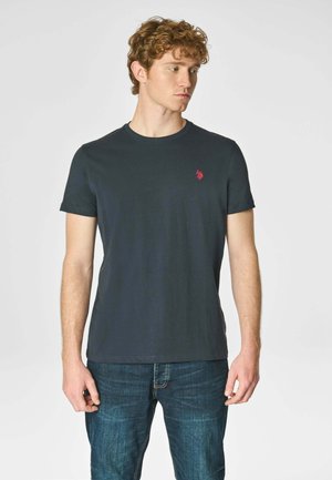 T-shirt di un blu navy scuro realizzata in cotone, con un classico collo a giro, maniche corte e un piccolo logo polo rosso sul petto.