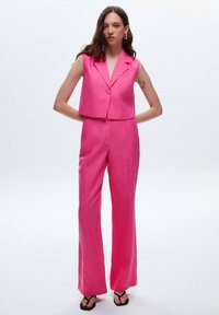 Roze linnen cropped vest met een enkele knoopsluiting en bijpassende wijduitlopende broek. Heeft een soepele textuur en een minimalistisch ontwerp.