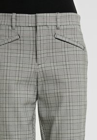 Gray and white plaid trousers with a tailored fit, featuring angled front pockets, smooth texture, and a classic check pattern.