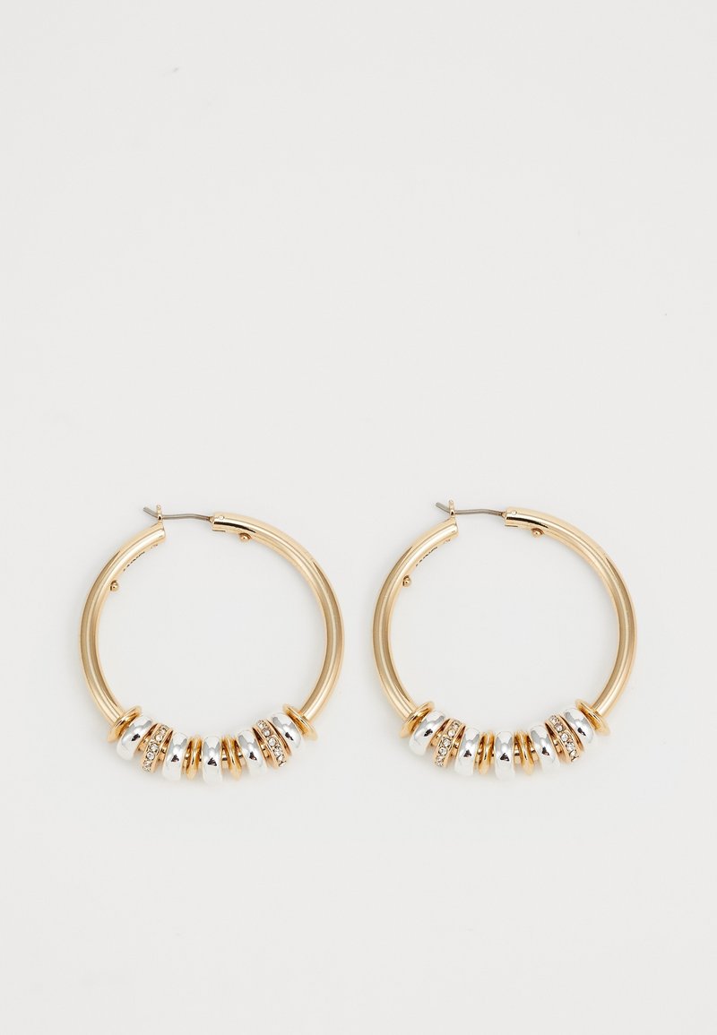 Boucles d'oreilles créoles en or avec des perles circulaires alternant or, argent et incrustées de cristaux sur un fond blanc.