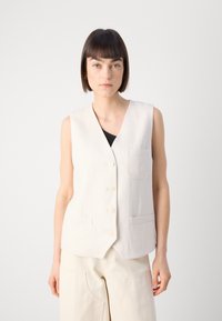 Crème-kleurige linnen gilet met een V-hals, vijf knopen en twee voorzakken; heeft een gestructureerde stof en een getailleerd ontwerp.