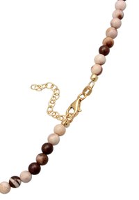 Perlenkette mit glatten, abwechselnd beige- und braunfarbenen Steinen, goldfarbenem Karabinerhaken und verstellbarer Verlängerungskette.