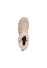 Botte de cheville en suède beige avec un col en fausse fourrure pelucheux, un bout arrondi et une doublure intérieure noire. Détails de couture en tan le long de la semelle.