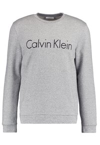 Sudadera gris de tela suave, con cuello redondo y mangas largas. Logo de "Calvin Klein" impreso en negro en el pecho.