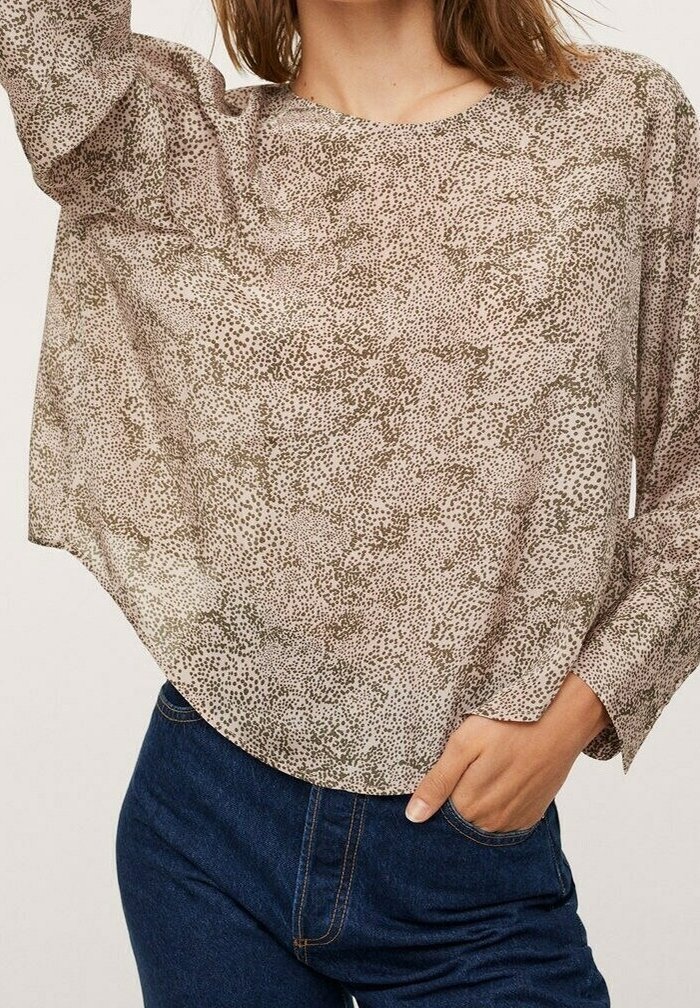Blouse légère à motifs beige avec des taches sombres, col rond et manches longues. Le tissu est transparent avec une coupe ample et fluide.